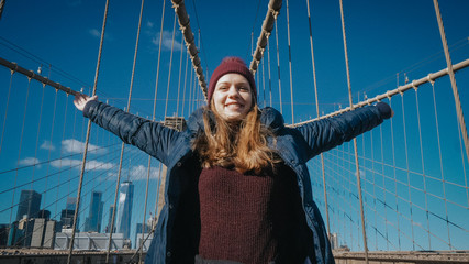Young happy woman on Brooklyn Bridge in New York