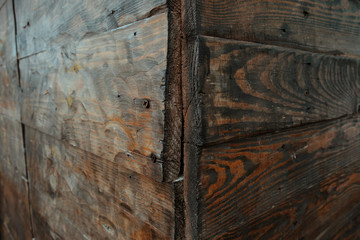 Obraz premium Corner view of a rotten wall made from wood, wooden texture background