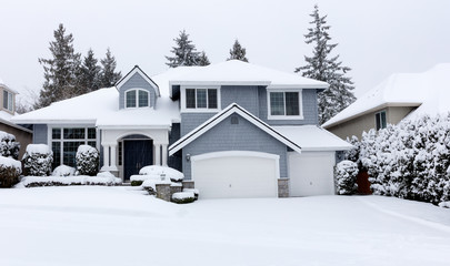 Snowing with residential Pacific Northwest home in background