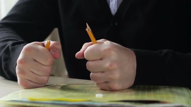 Angry man breaking pencil. Angry and frustrated businessman
