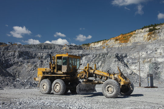 Grader in a quarry for limestone mining. Mining industry.