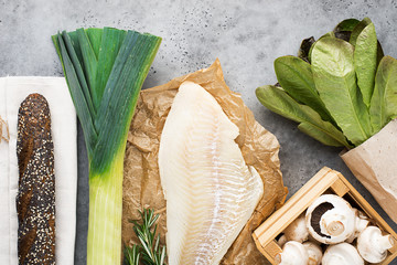 Zero waste products shopping. Cod fillet, champignons, leek, romaine lettuce on a light background...