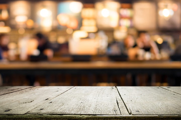 Wooden table with blur background of coffee shop.