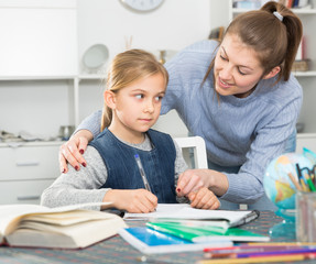 Woman helping her daughter with hometask