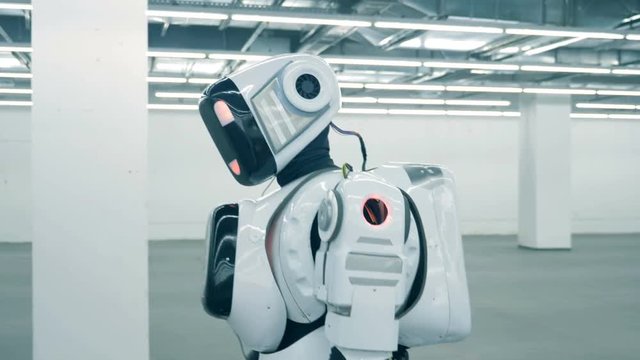 One robot, futuristic android, cyborg walks in a room alone. Futuristic humanoid robot