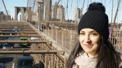 Beautiful girl enjoys the walk over Brooklyn Bridge New York