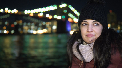 Portrait shot of a young woman at Brooklyn Bridge by night