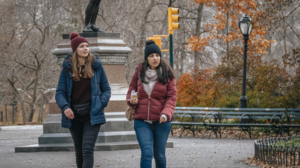 Two young woman on a trip to New York take a relaxing walk in Central Park