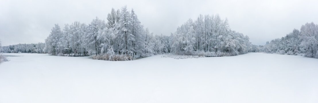 Panoramic aerial view of winter beautiful landscape with trees covered with hoarfrost and snow. Winter scenery from above. Landscape photo captured with drone.