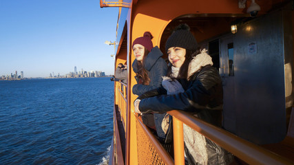 Fototapeta na wymiar Two girls ride the Staten Island Ferry on a sunny day