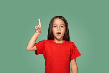 Little girl in red t-shirt with finger up