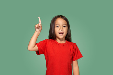 Little girl in red t-shirt with finger up
