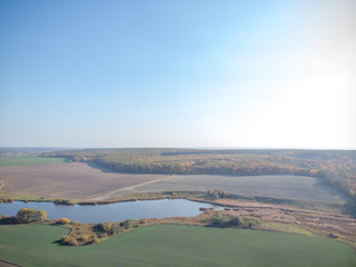 Autumn Aerial view shoot from drone, above field. view over agricultural fields and road. agricultural field. harvesting, sowing, fertilizers. bright yellow leaves, lakes, space for text