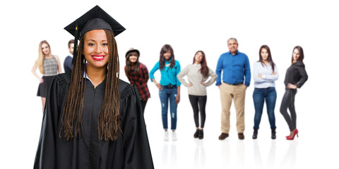 Young graduated black woman wearing braids cheerful and with a big smile, confident, friendly and sincere, expressing positivity and success