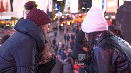 Obraz premium Two girls in New York enjoy the amazing view over Times Square by night