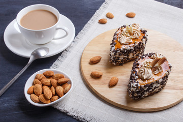 cakes with chocolate chips  and cream decorations  on wooden board on black wooden background.