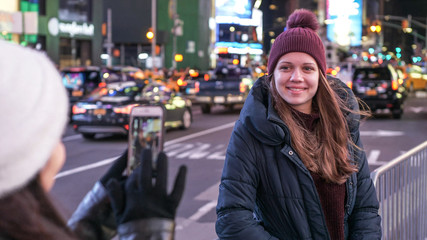 Two girls in New York take photos at Times Square