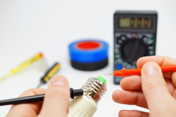 Electrician measures the serviceability of the lamp.