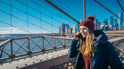 Young beautiful woman relaxes on Brooklyn Bridge while enjoying the amazing view