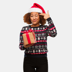 Young black woman holding a gift in christmas day doing a suicide gesture