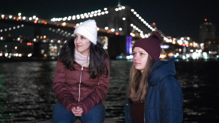 Two girls in New York enjoy the most beautiful place in the city at Brooklyn Bridge