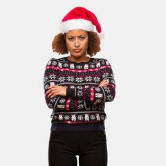 Young black woman in a trendy christmas sweater with print crossing arms relaxed