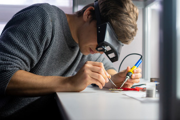 young scientist soldering microcircuit. science b