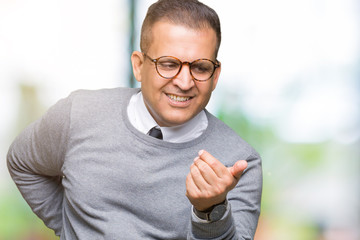 Middle age bussines arab man wearing glasses over isolated background Beckoning come here gesture with hand inviting happy and smiling