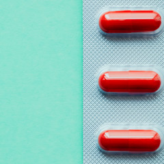 Blister bright red tablets on a green background.