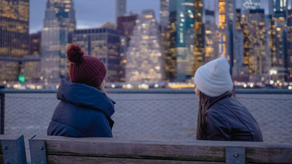 Two young woman enjoy a wonderful evening at the Manhattan skyline in New York