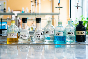 chemical flasks with acid stand in laboratory b