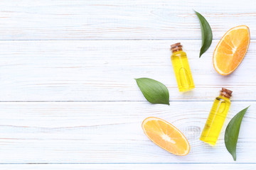 Orange oil in bottles with green leafs on wooden table