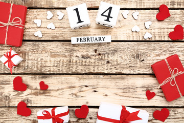 Fototapeta na wymiar Valentine day on wooden blocks with hearts and gift boxes