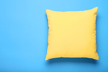 Soft yellow pillow on blue background
