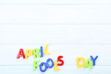 Inscription April Fool's Day by colorful letters on wooden table