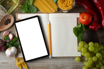 diet plannig. Set of raw food with tablet on wooden background with gadget screen with copy space. Healthy food concept, top view. Healthy food concept.