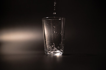 On a black background in a glass of water poured
