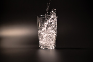 On a black background in a glass of water poured