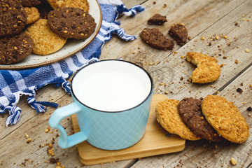Cookies platter and glass of milk on wooden background.