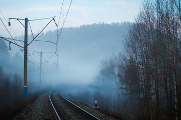 view of railway and electric poles in fog in spring