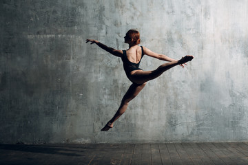 Ballerina female. Young beautiful woman ballet dancer, dressed in professional outfit, pointe shoes and black body.