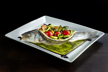 Baked, stuffed fish. Filling of salted cucumbers, tomatoes and onions.