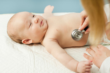 small child, child, lies in the doctor's office, and the doctor listens to the lungs, heart. The concept of children's health