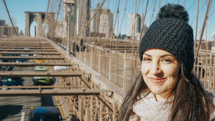 Beautiful girl enjoys the walk over Brooklyn Bridge New York