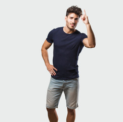 Fototapeta premium Young handsome man standing showing number one, symbol of counting, concept of mathematics, confident and cheerful