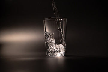 On a black background in a glass of water poured