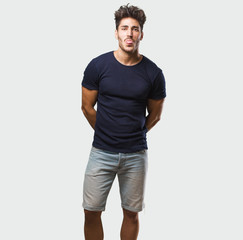 Fototapeta premium Young handsome man standing expression of confidence and emotion, fun and friendly, showing tongue as a sign of play or fun