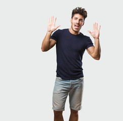 Young handsome man standing crazy and desperate, screaming out of control, funny lunatic expressing freedom and wild