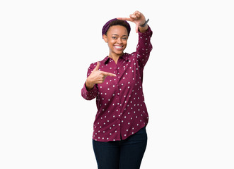 Beautiful young african american woman wearing head scarf over isolated background smiling making frame with hands and fingers with happy face. Creativity and photography concept.
