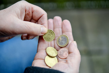 Ältere Frau zählt Kleingeld in der Hand - selektive Schärfe